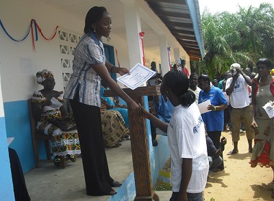 A proud graduate receives her graduation certificate, Liberia, 2013